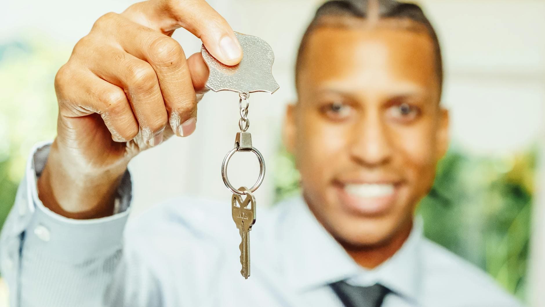 Real estate agent handing house keys to new homeowners after closing — Middle Tennessee neighborhood porch