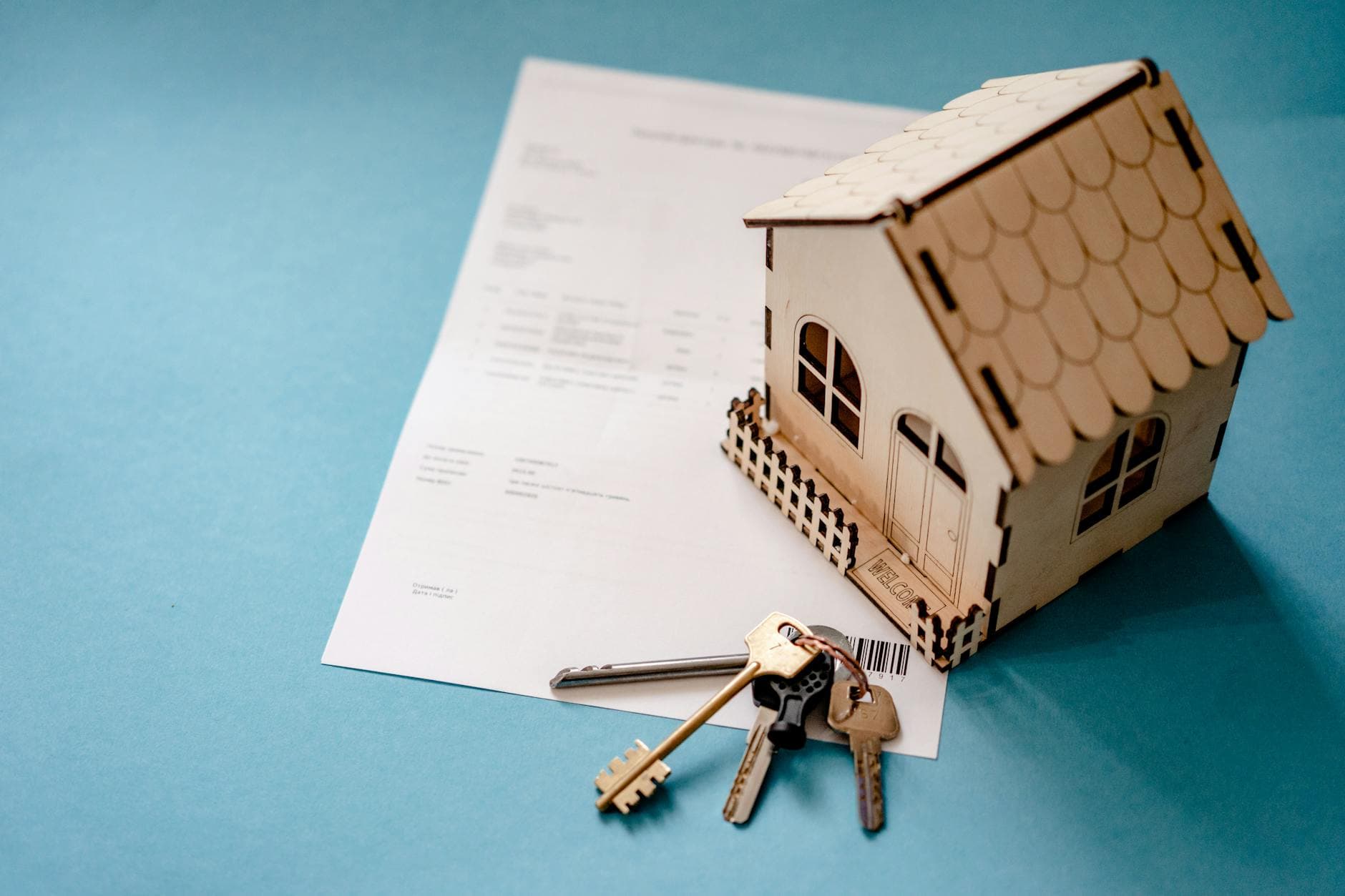 Set of house keys resting on a notarized closing-table contract — handover after a Middle Tennessee home sale