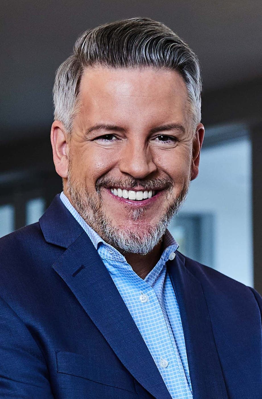 Brady Sandahl, Luxury Director of Growth at KW International, smiling in a navy blazer