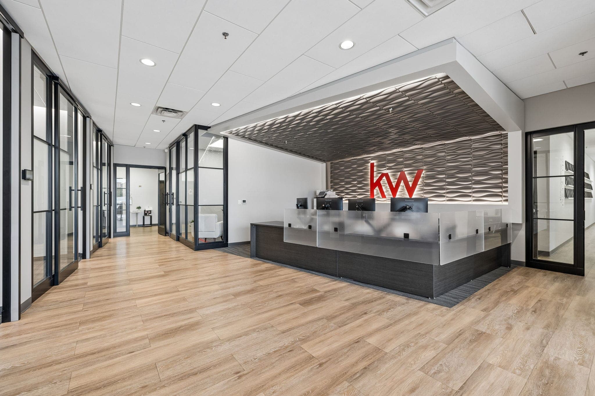 Backlit reception wall with the red KW mark welcoming visitors to the Franklin market center