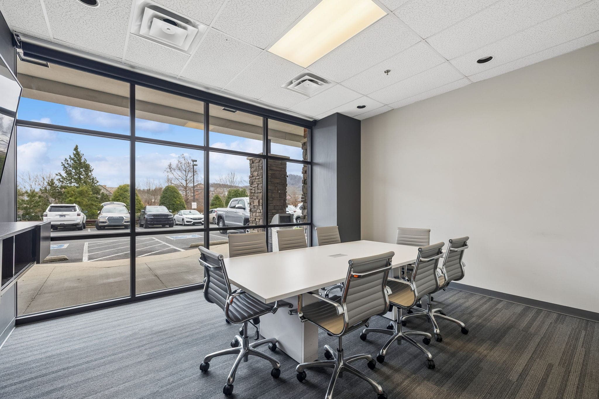 A white conference table set for six beneath a wide window at the Franklin office