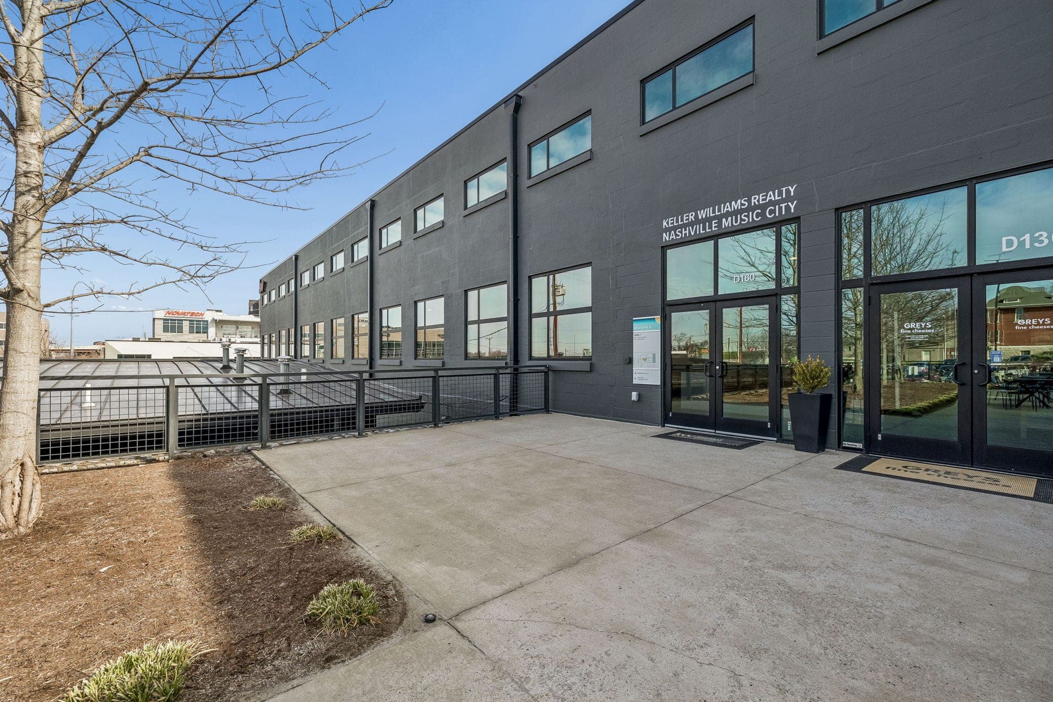 Charcoal industrial facade and glass entry of the Keller Williams Nashville Music City office